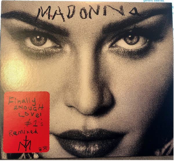 Close-up of Madonna’s face with red sticker on album cover.