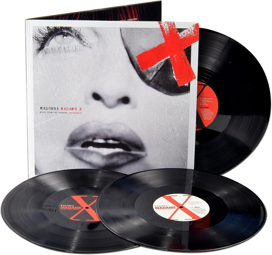 "Three black vinyl records with red labels and a white album cover featuring a face."