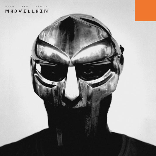 Black and white close-up of a person wearing a metallic gladiator-style mask.