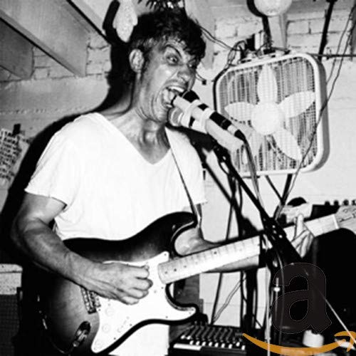 Black and white photo of a musician playing guitar and singing.