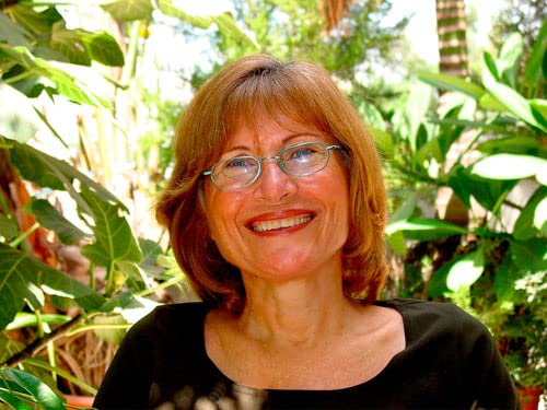Woman with short brown hair and glasses smiling at the camera.