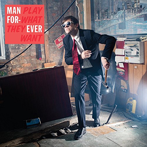 Man in suit running through a cluttered room, album cover.