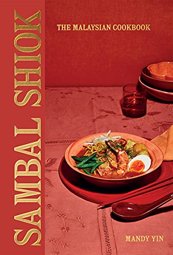 Cookbook cover with food photography, red and gold lettering, and table setting.