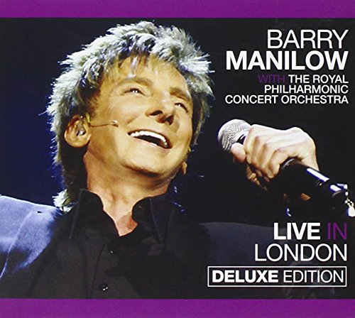 Barry Manilow smiling and holding a microphone on a dark background with purple accents.