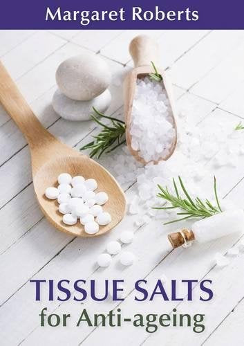 Book cover with white pills, stones, and rosemary on wood.