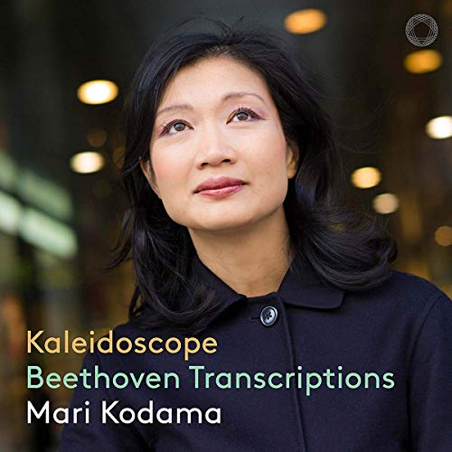CD album cover featuring Mari Kodama with blurred background lights and multicolored text overlay.