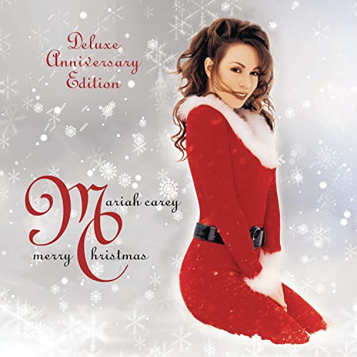 Mariah Carey in a red coat with white fur trim, snowy background.