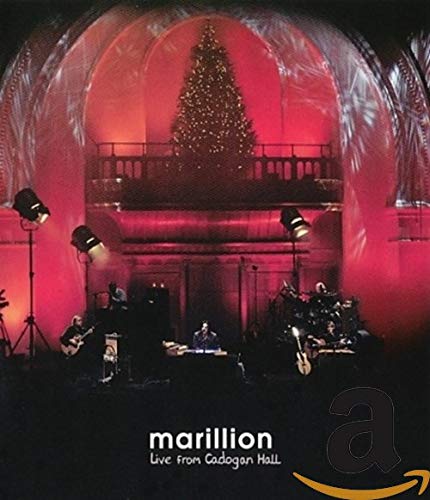 Marillion band performing live on stage with a Christmas tree backdrop.