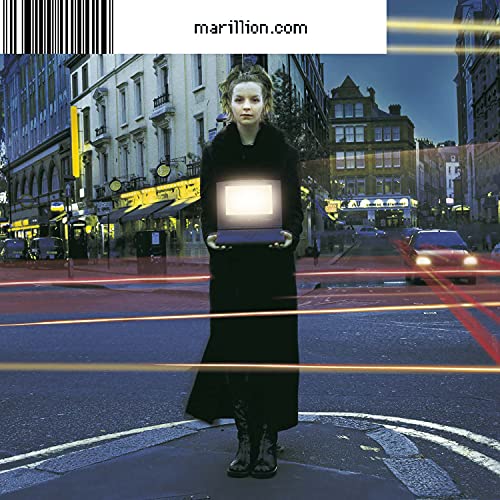 A person in a black coat holds a glowing laptop on a city street.