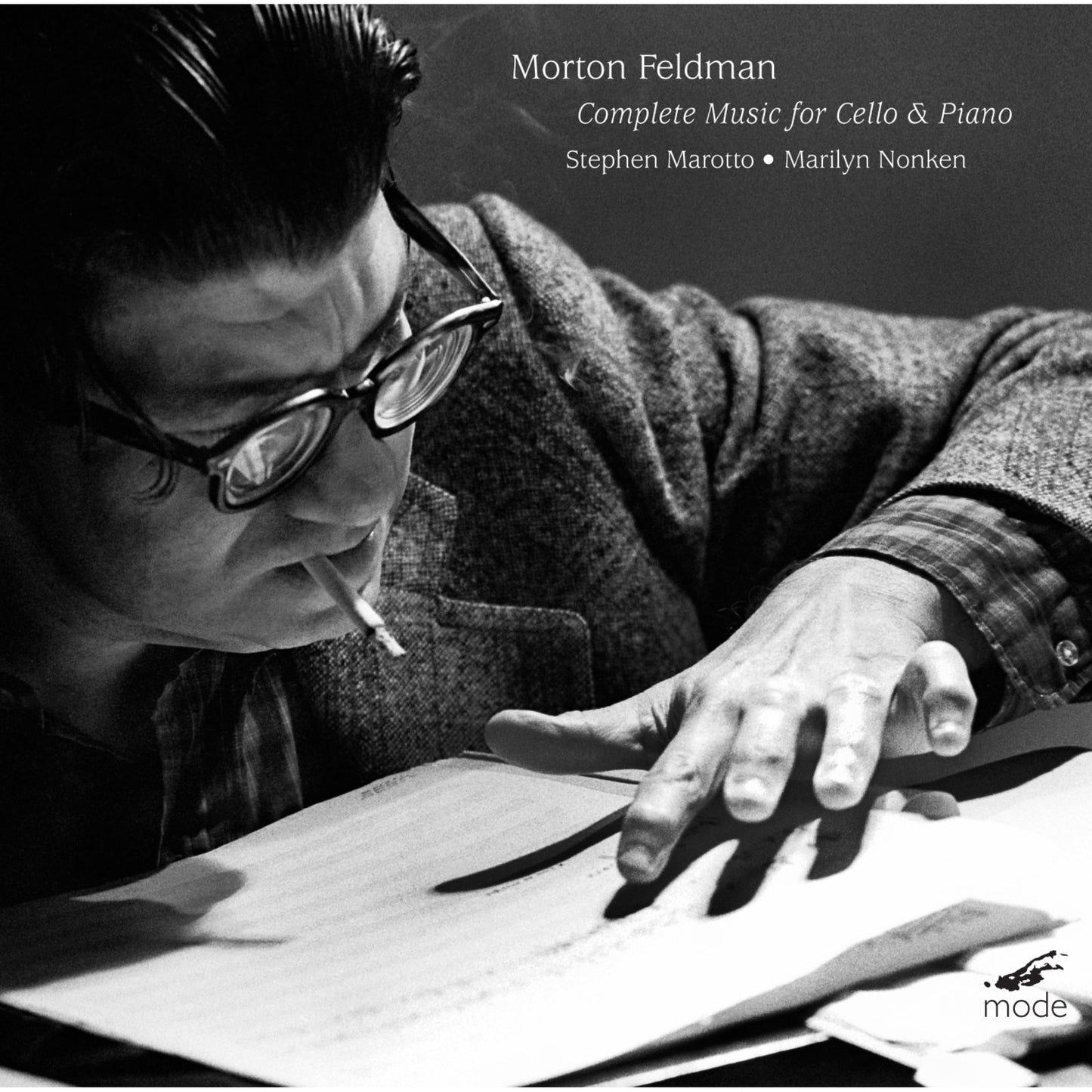 Black and white portrait of a man with glasses writing music.