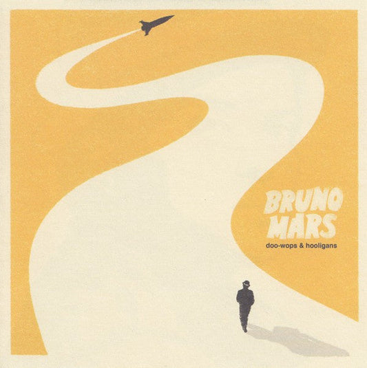 Bruno Mars album cover: yellow background, jet and silhouetted figure.