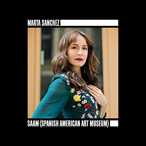 A portrait of Marta Sanchez wearing a teal floral shirt against a wooden background.
