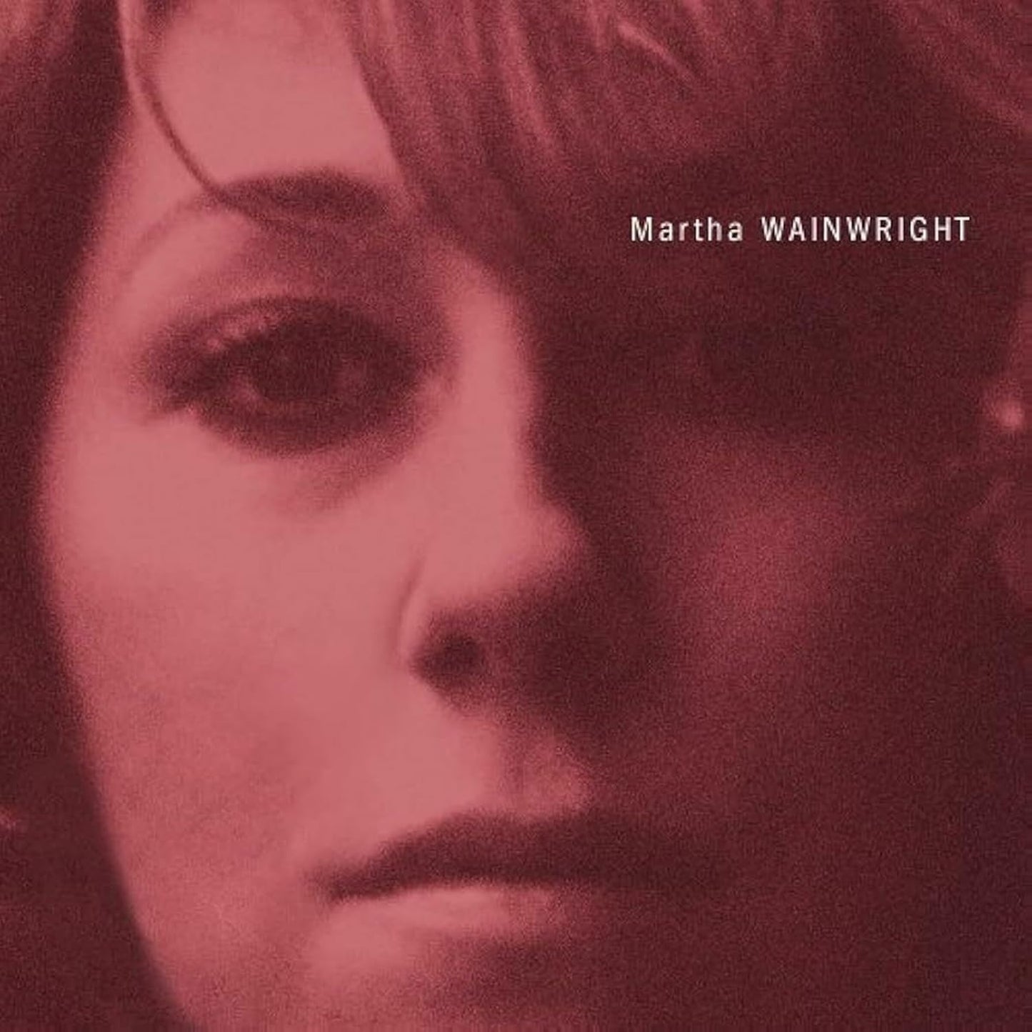 Close-up portrait of Martha Wainwright in a dark red, high-contrast monochromatic style.