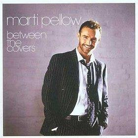 Marti Pellow wearing a pinstripe suit and tie against a light purple background.