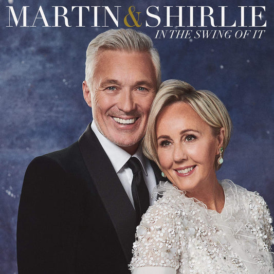 Martin and Shirlie Kemp smiling together, man in suit, woman in white dress.