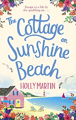 Book cover: beach cottage, blue sea, flowers, and handwritten title.