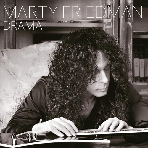 Marty Friedman with long curly hair playing an electric guitar in black and white.