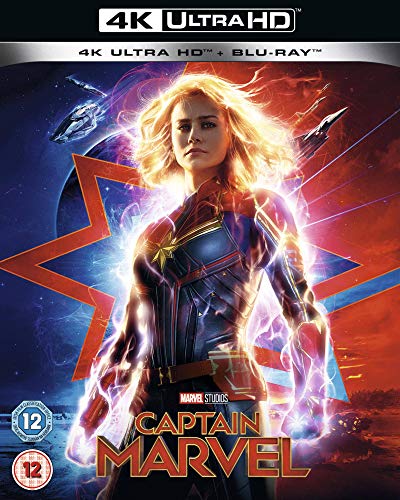 "Blonde woman in superhero costume with glowing fists, against a star emblem background."