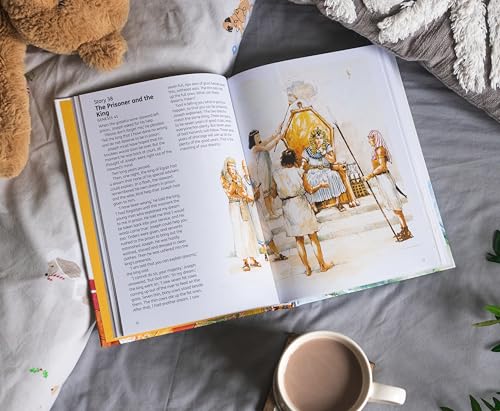 Open children’s Bible storybook with illustration of ancient figures, beside a teddy bear.