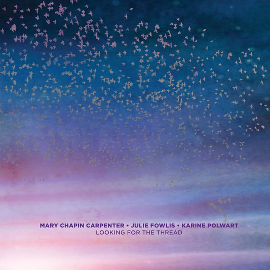 A flock of birds flies across a blue and pink gradient sky at sunset.