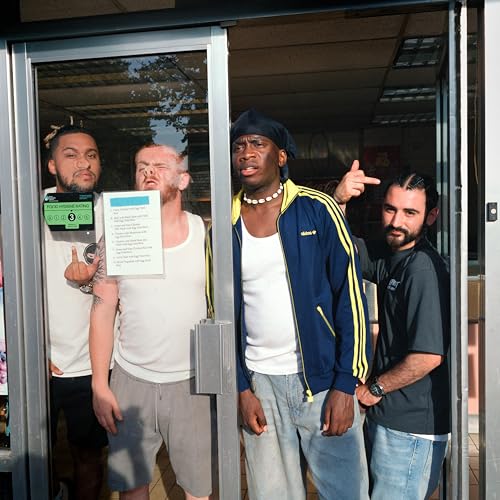 Four men stand in a glass doorway, one holding a sign, others gesturing.