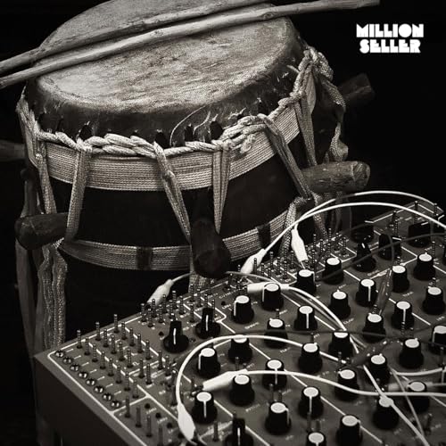 Black and white album cover featuring a drum and electronic music equipment.