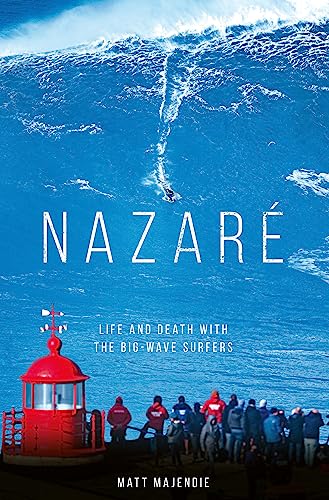 A surfer rides a massive wave near a red lighthouse with spectators watching below.