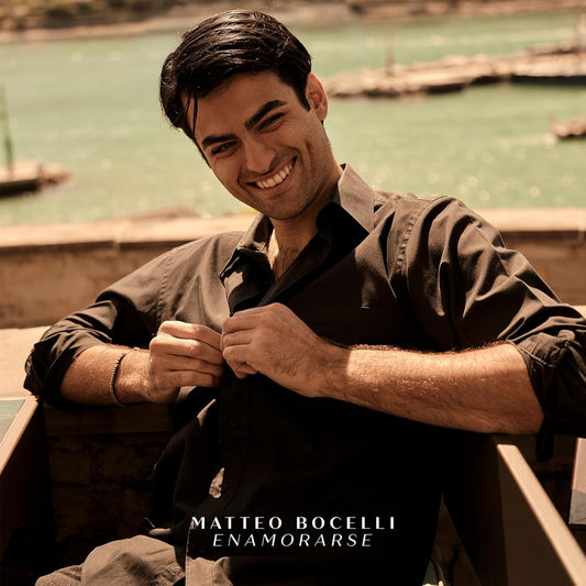 Matteo Bocelli smiling on CD cover, warm tones, waterfront background.