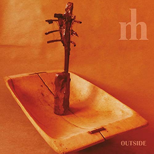 Album cover: wooden trough with a twig sculpture, orange background.