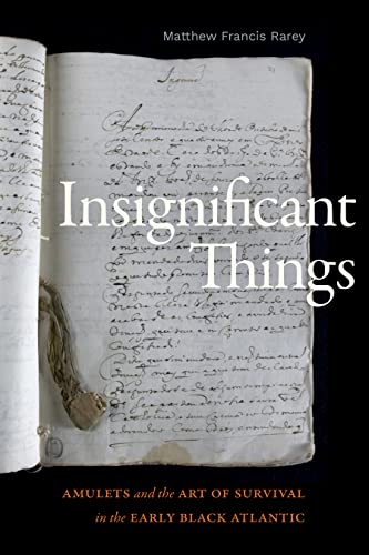 Book cover with handwritten text and a small tied amulet.