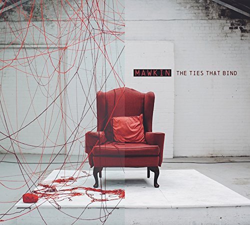 Red armchair entangled in red strings on a white mat, against a white brick wall.