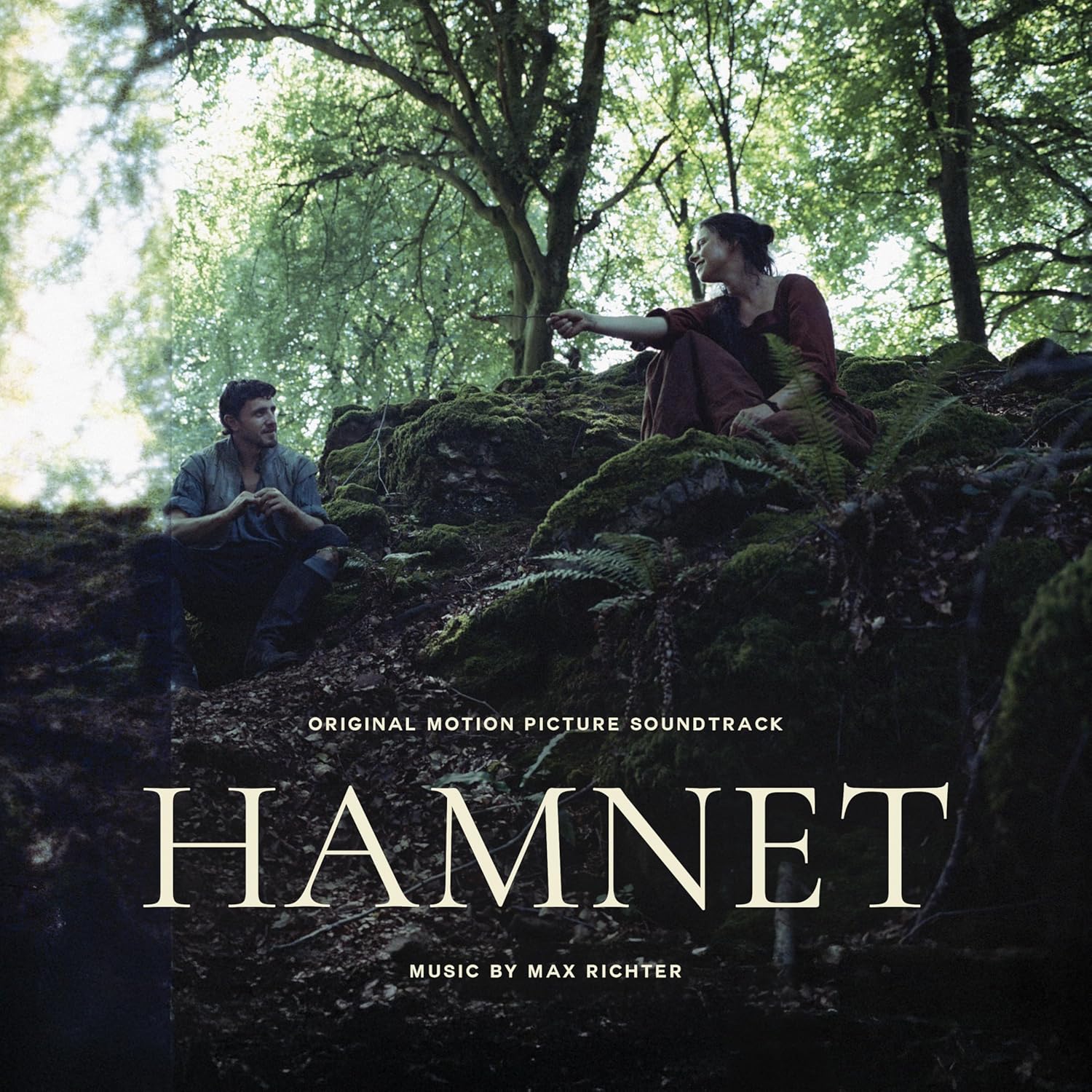 Film poster for "Hamnet" showing a couple in a mossy forest.