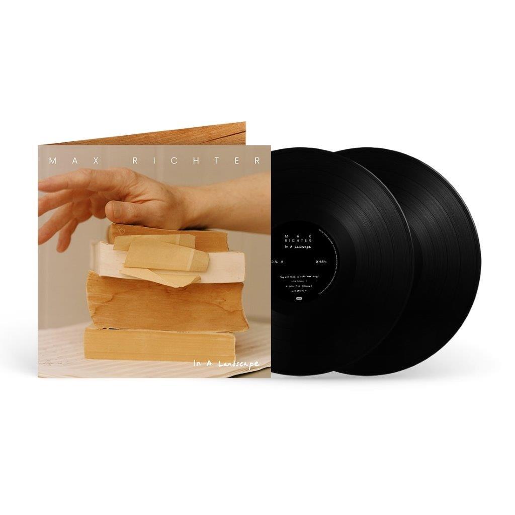 Vinyl record set and album cover featuring a hand resting on a stack of books.