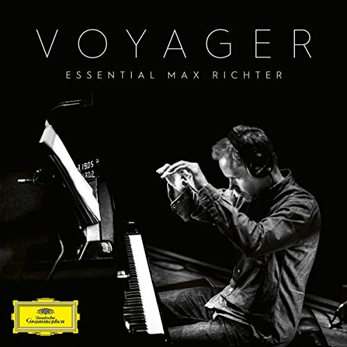 Max Richter wearing headphones and playing the piano on a black background.