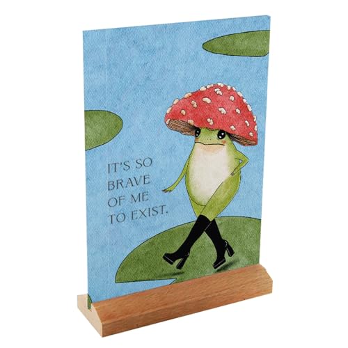 Frog with mushroom hat on blue card, displayed on wooden stand.