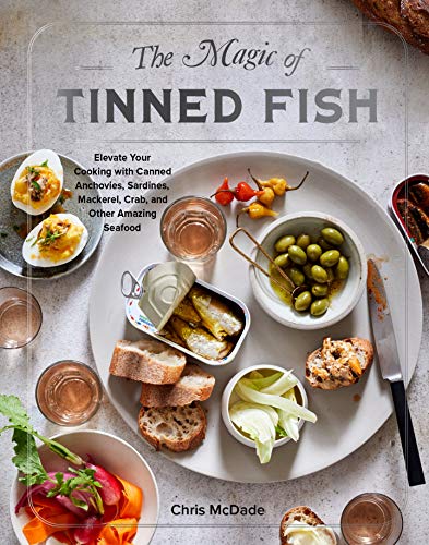 Cookbook cover featuring tinned fish, olives, eggs, and small plates.
