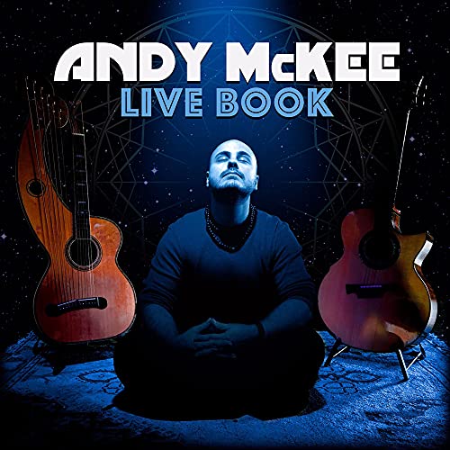 Andy McKee sits cross-legged between two acoustic guitars against a blue starry background.