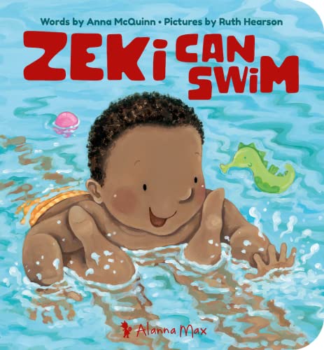 A young child with dark curly hair smiling while swimming in blue water.