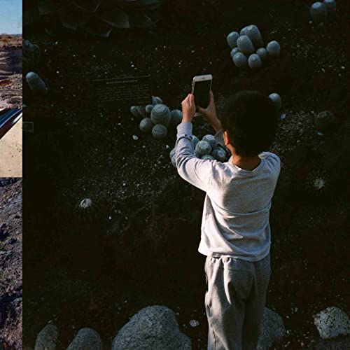 Child taking photo of dinosaur eggs with smartphone in dark setting.