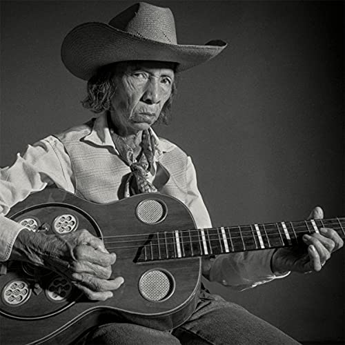 Black and white portrait of an older man playing a guitar.