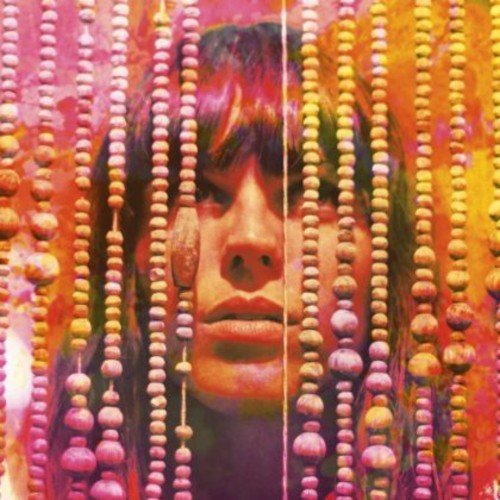 Woman’s face framed by colorful beaded curtains, close-up view.