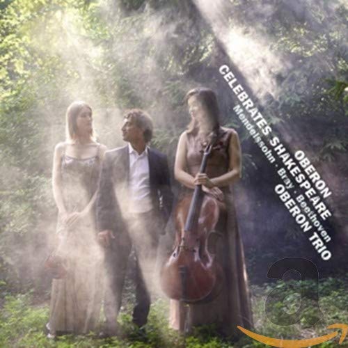 CD cover featuring three musicians with a cello in a forest setting.