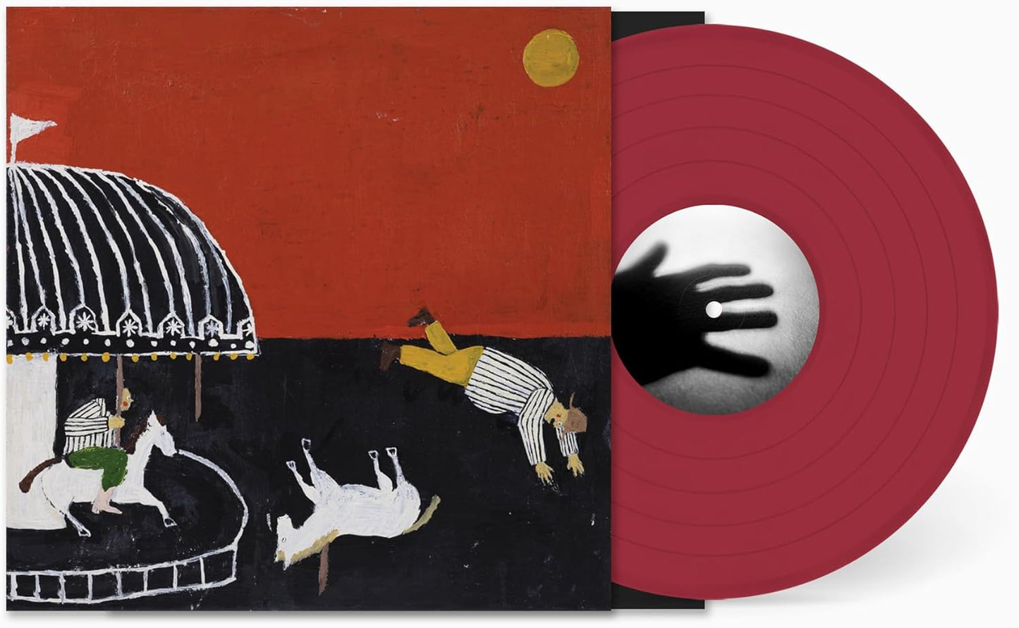 Vinyl record with red disc and album cover depicting a carousel and falling figures.