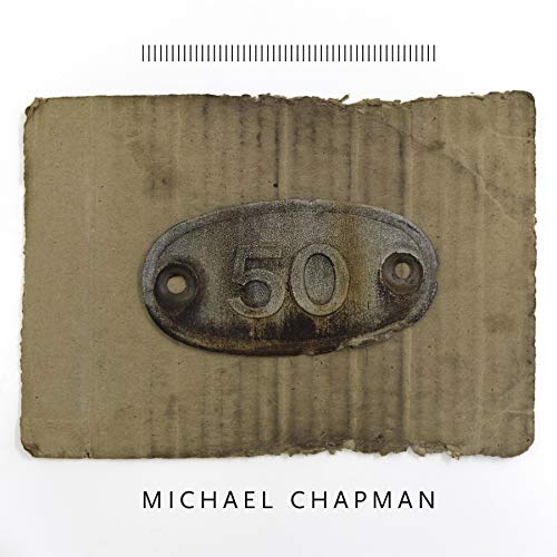 A weathered oval metal plate with the number 50 on a piece of cardboard.