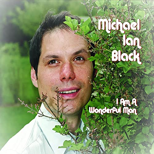 Michael Ian Black smiling next to a green bush on a CD cover.