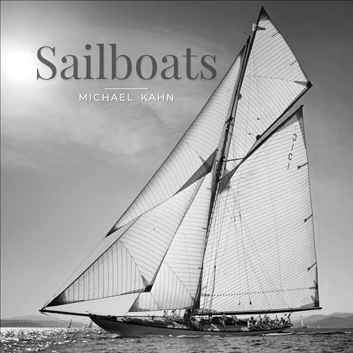 Black and white photograph of a sailboat with full sails on water.