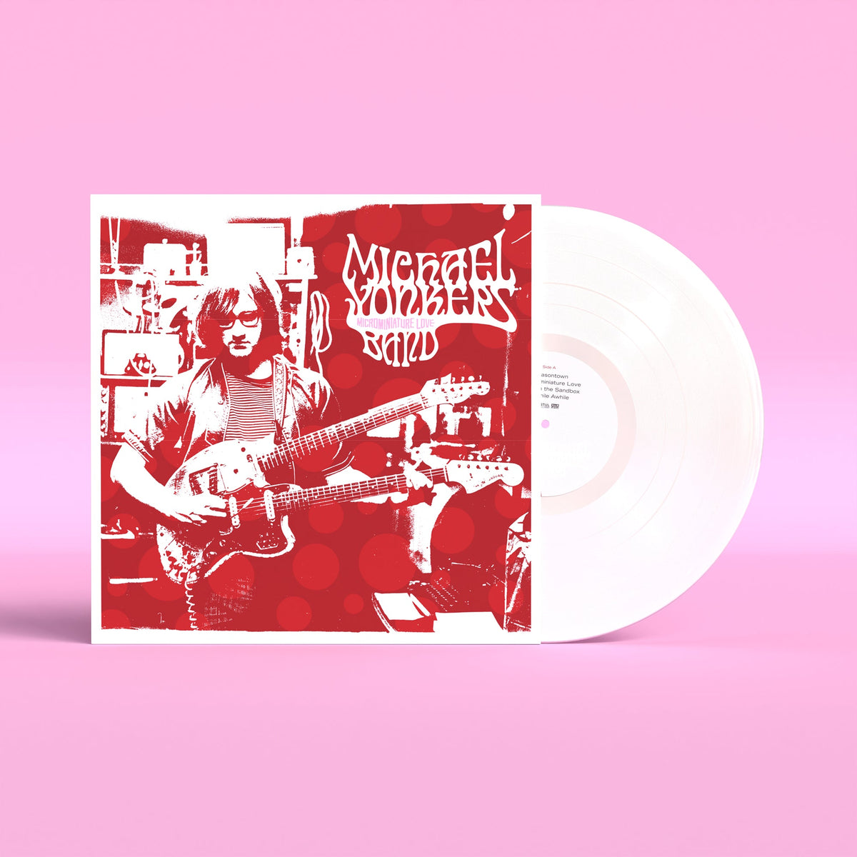 Vinyl record and cover featuring a red-toned image of a guitarist on pink background.