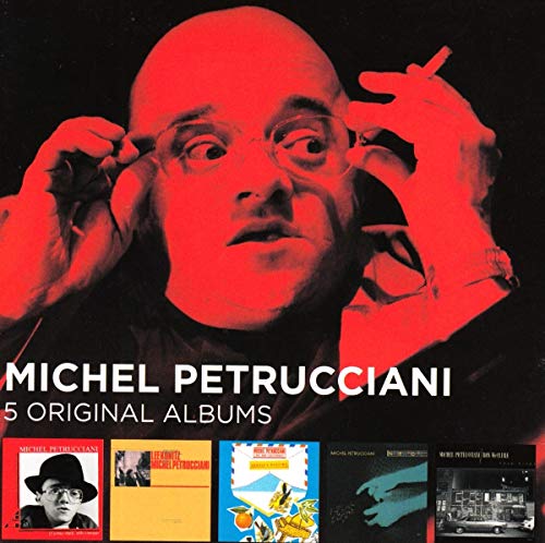 Portrait of Michel Petrucciani in red lighting above five small album cover thumbnails.