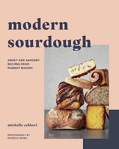 Cookbook cover featuring stacked sourdough breads and pastries, peach background.