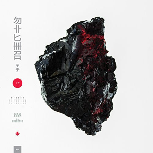 A jagged black mineral with red highlights centered on a white background.